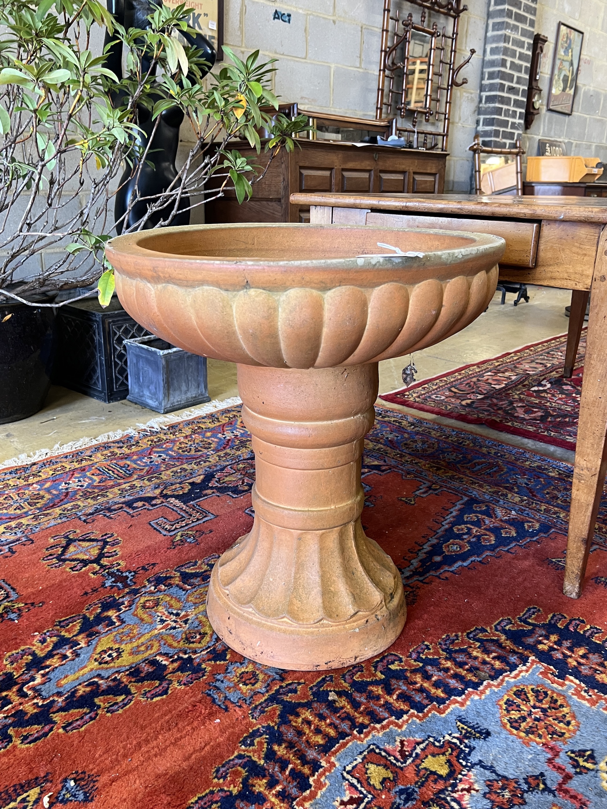 A circular terracotta garden planter, diameter 60cm, height 67cm